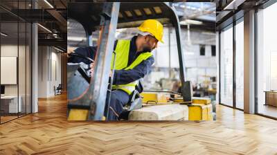 worker wearing helmet with driving forklift backwards in warehouse Wall mural