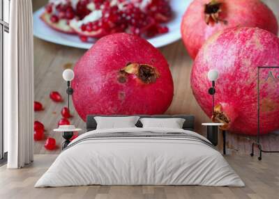 Fresh red pomegranates on wooden table Wall mural