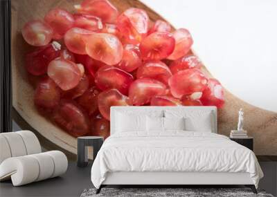 Pomegranate fresh pink seeds close-up in a wooden spoon Wall mural