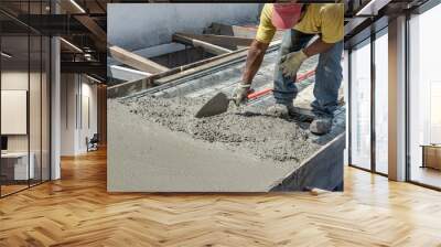 Bricklayer leveling a cement roof. Stretching out to smooth the casted concrete mix   Wall mural