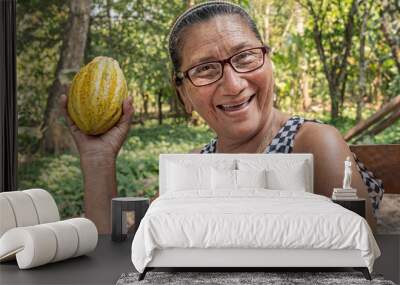 Woman cheerfully showing a cacao pod in Tabasco, Mexico.
Proud Mexican farmer holding her recent cocoa harvest. Wall mural