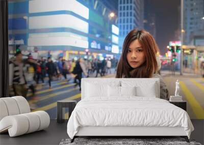 Beautiful young girl stand out and watching at night in hong kong, lost in city , busy crowd and yellow zebra crossing blurred background  Wall mural