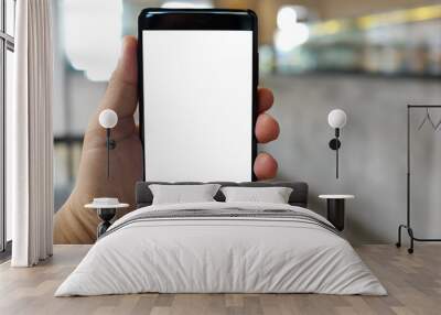 Cropped shot view of man hand holding a smartphone in the cafe with blank copy space screen for text message or information content Wall mural