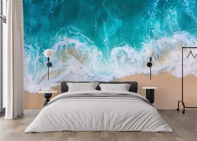 An aerial view captures the gentle embrace between the azure waves and the soft sandy beach, creating a tranquil and picturesque scene  Wall mural