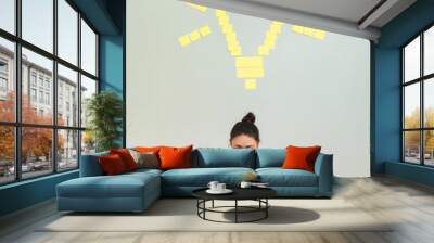 Idea concept, woman with yellow sticky notes shaped in light bulb Wall mural