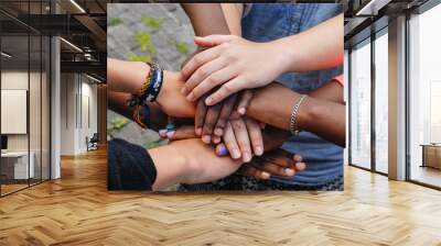 multiracial teenagers joining hands together in cooperation Wall mural