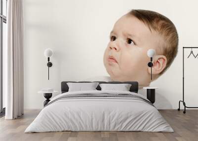 Cute baby boy looking up upset. Baby looking disgusted. Wall mural