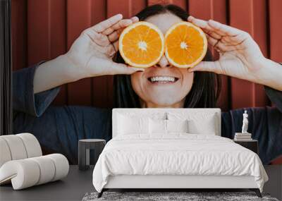 .Funny portraits of a pretty girl with two fresh oranges in her eyes with different expressions. Lifestyle portrait Wall mural