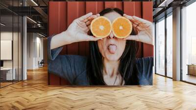 .Funny portraits of a pretty girl with two fresh oranges in her eyes with different expressions. Lifestyle portrait Wall mural