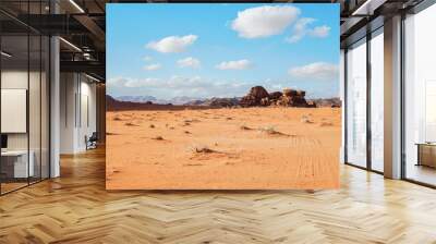 Orange red sand desert, rocky formations and mountains background, blue sky above - typical scenery in Wadi Rum, Jordan Wall mural