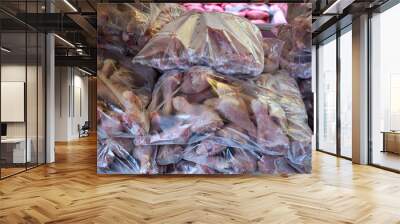 Raw meat - chicken and poultry legs - in plastic bags on display at butcher shop window Wall mural