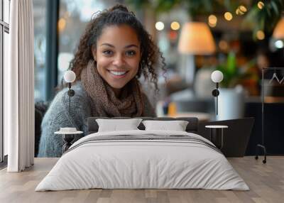 Beautiful young freelancer woman smiling while working on laptop in cafe Wall mural