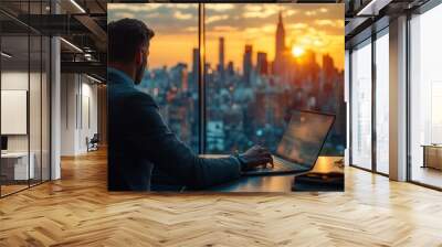 Businessman working on laptop at desk in new york city at sunset Wall mural