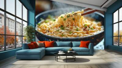 Chopsticks lifting noodles from steaming bowl of ramen Wall mural