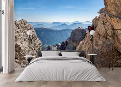 Male mountain climber on a Via Ferrata in breathtaking landscape of Dolomites Mountains in Italy. Travel adventure concept. Wall mural