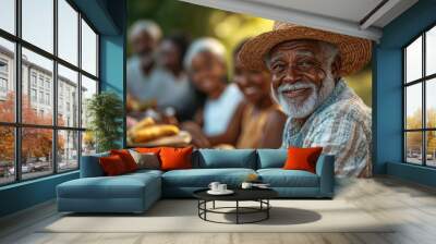 Senior farmer smiling with family enjoying meal outdoors Wall mural