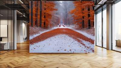 Winding road covered with red leaves in a snowy forest Wall mural