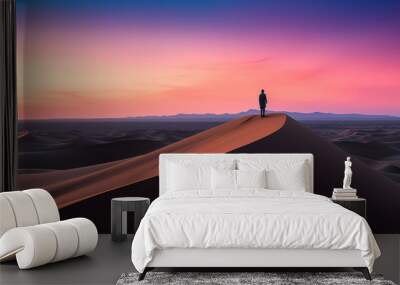 A lonely man silhouetted standing on top of a sand dune in the middle of a desert with the amazing soft, orange, and pink sunset - Generative AI Wall mural