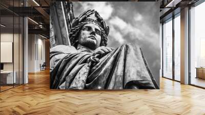 Grayscale of the male statue under a cloudy sky Wall mural