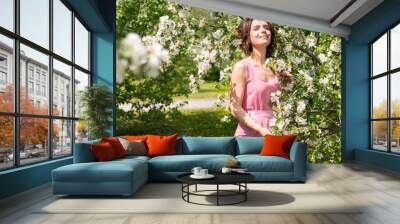 A woman near a blooming spring tree. Romantic happy mood. Wall mural