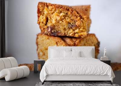 a pile of stacked slices of brown sugar cashew blondies, a vegetarian and vegan dessert with dates, dried fruits on a white background table and plate Wall mural