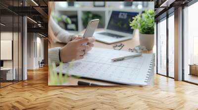 Event planner timetable agenda plan on organize schedule event. Business woman using mobile phone and taking note on calendar desk on office table Wall mural