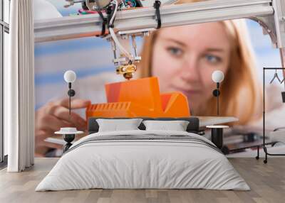 A female student or laboratory assistant in the automation laboratory is debugging the work of the 3d printer. 3d printer is a device for modeling 3D objects Wall mural