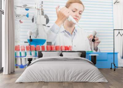 Experiments in the chemical laboratory, Female researcher using her test tube in a laboratory Wall mural