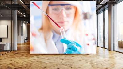 Female laboratory assistant with chemical experiment in scientific laboratory Wall mural