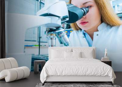 Scientist using a microscope in a laboratory Wall mural