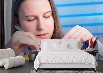 Young woman fix PC component in service center Wall mural