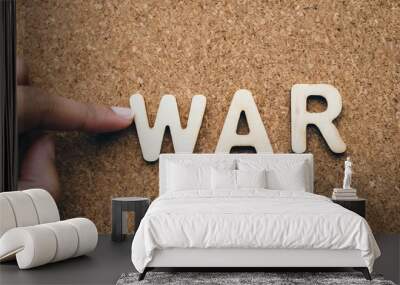 war wood word on compressed or corkboard with human s finger at r letter Wall mural