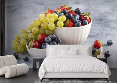 Fresh berries in bowl on grey background Wall mural