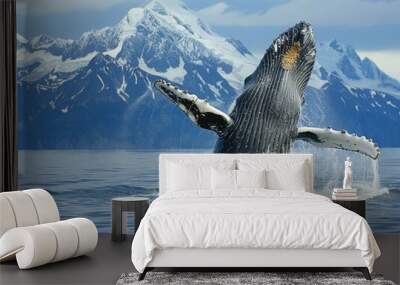 A dramatic moment as a humpback whale breaches the ocean's surface off Alaska's coast, with snow-capped mountains providing a stunning backdrop, epitomizing the raw power and beauty of marine wildlife Wall mural