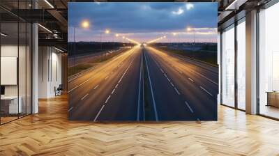 A quiet highway at dusk, illuminated by streetlights, with a soft glow on the asphalt Wall mural