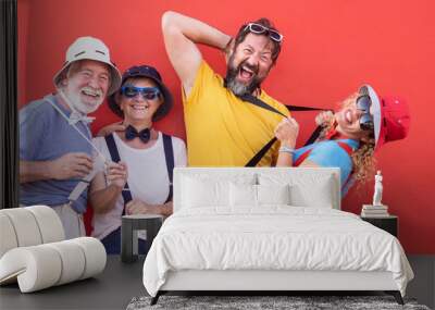 Group of adult happy people senior and middle aged playing outdoor against a red wall. Dressed in a fanny way with bow tie and suspenders. Full of color, party or celebration day Wall mural