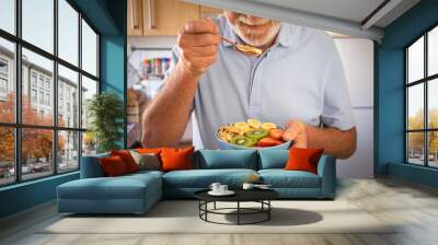 Senior man ready to eat a salad of fresh and dried fruits. Breakfast or lunch time, healthy eating Wall mural