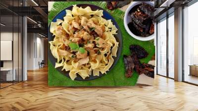 Italian food with pasta tagliatelle,sun dried tomatoes,basil and chicken meat on green cloth on wooden background Wall mural