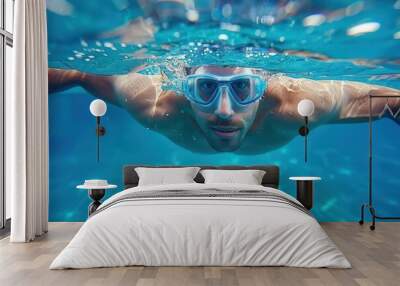 man swimming laps in pool with goggles healthy exercise and leisure activity underwater view Wall mural