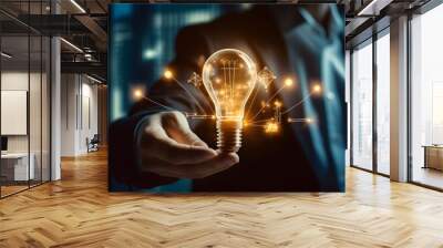 Businessman holding creative light bulb with growth graph and banking icons. Financial innovation technology develop new products and services that enhance successful and profit in global business. Wall mural