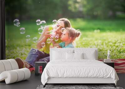 Happy Childhood – Young Mother and child blows soup foam and make bubbles . Wall mural