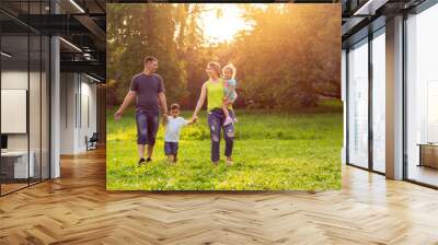 Young family together enjoying in park. Wall mural