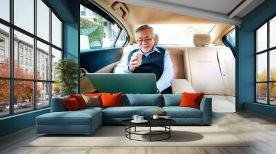 Adult senior executive luxury business old man sitting with laptop computer at back of car seat ,Technology transport lifestyles concept. Wall mural