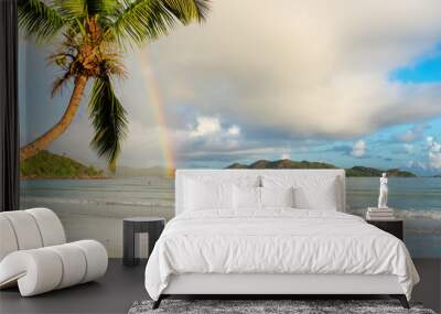 Coco palm and rainbow on exotic tropical beach at morning in Seychelles. Wall mural