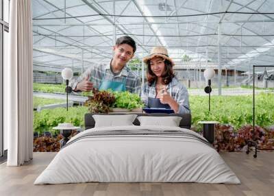 2 Farmer inspect the quality of vegetable organic salad and lettuce from hydroponic farm and make notes on clipboard to give customers the best product Wall mural