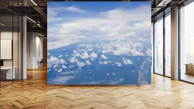 Clouds from airplane window with blue sky and high angle ground Wall mural