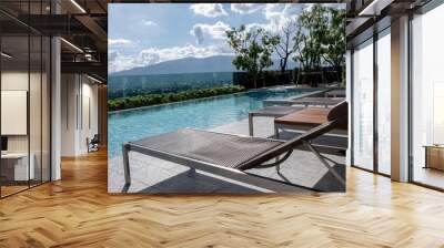 Picture of a sun bed chair on the edge of a hotel or resort rooftop swimming pool Wall mural