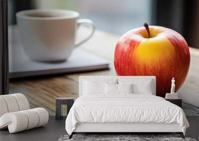 A vibrant red apple beside a coffee cup on a wooden table, capturing a cozy and inviting morning ambiance. Wall mural