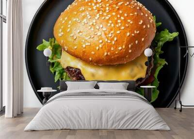 Delicious cheeseburger topped with fresh lettuce and tomato on a sesame seed bun, served on a black plate. Wall mural