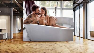 boy and girl is bathing together and drinking champagne. Wall mural